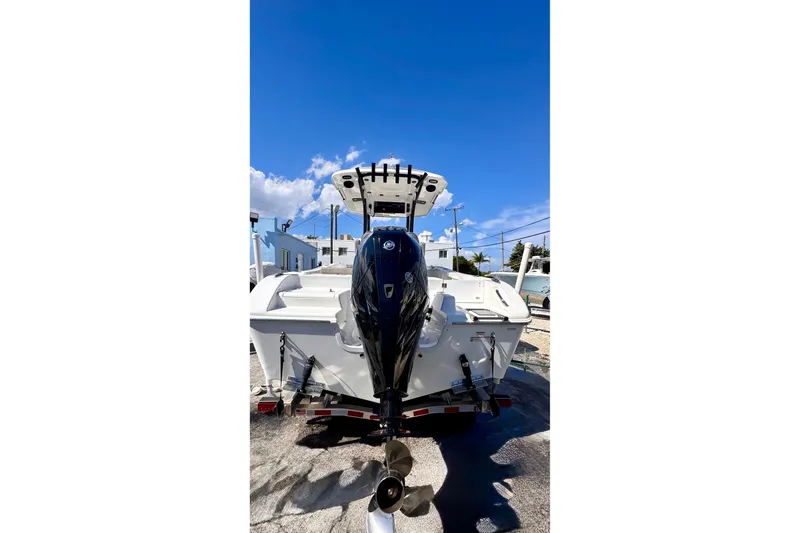 Slide: The Image of 2024 Sea Pro 242 boat with outboard motor, parked under clear blue sky. - 3