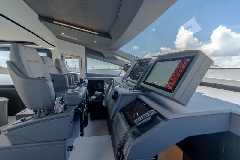 Slide: The Image of Cockpit of 2021 Pershing 9X yacht with modern navigation screens and luxurious seating. - 21