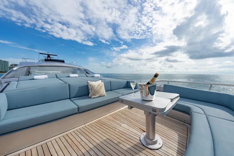 Slide: The Image of Luxurious 2021 Pershing 9X yacht deck with champagne, ocean view, and elegant seating. - 49