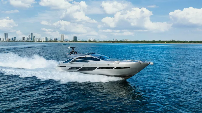 Slide: The Image of Luxury Pershing 9X yacht cruising on open water, city skyline in background, 2021 model. - 6