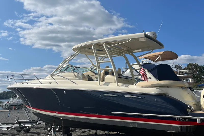 Slide: The Image of 2016 Chris-Craft Launch 36 boat with American flag, docked under a clear blue sky. - 0