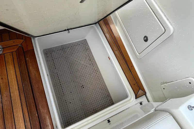 Slide: The Image of 2016 Chris-Craft Launch 36 storage compartment with wooden flooring and white interior. - 14