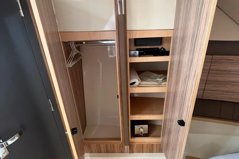 Slide: The Image of 2016 Chris-Craft Launch 36 interior closet with shelves and hangers. - 19