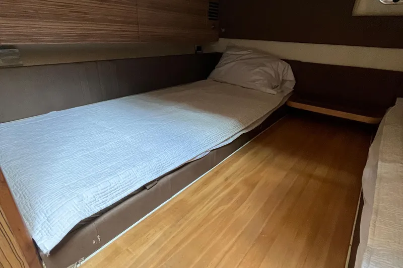 Slide: The Image of 2016 Chris-Craft Launch 36 cabin interior with wooden flooring and cozy bedding. - 24