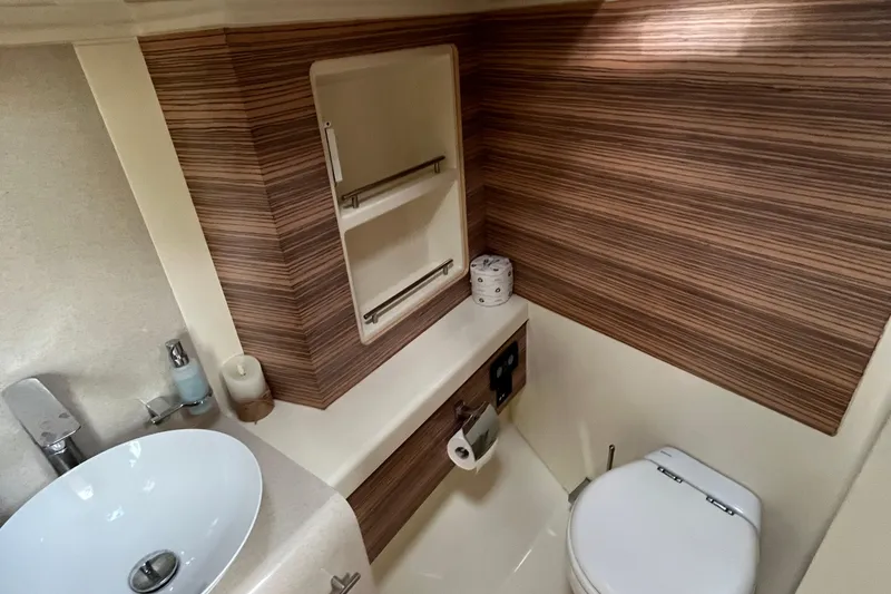 Slide: The Image of 2016 Chris-Craft Launch 36 bathroom with modern sink, toilet, and wood paneling. - 28