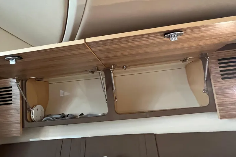 Slide: The Image of 2016 Chris-Craft Launch 36 interior cabinet with open wooden doors and storage space. - 33