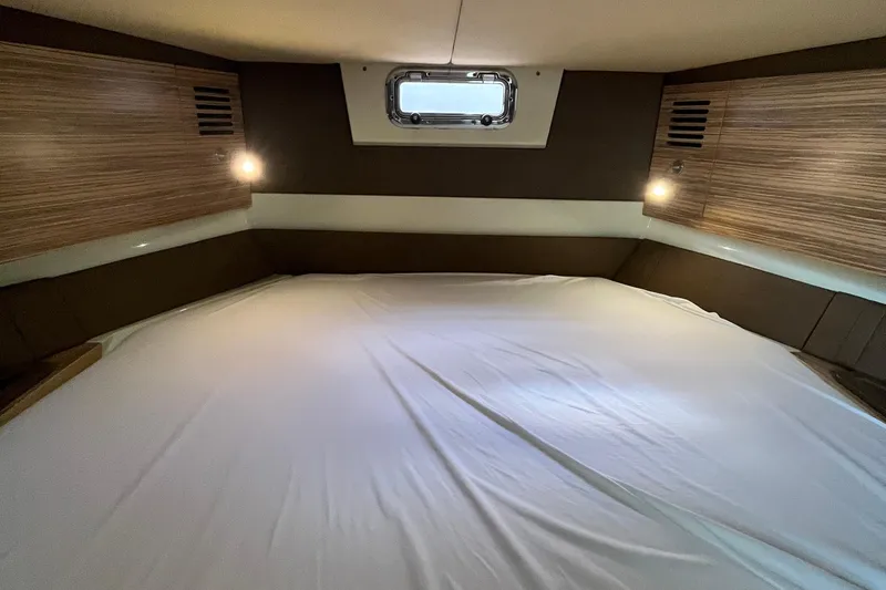 Slide: The Image of 2016 Chris-Craft Launch 36 cabin interior with bed, wood paneling, and window. - 34