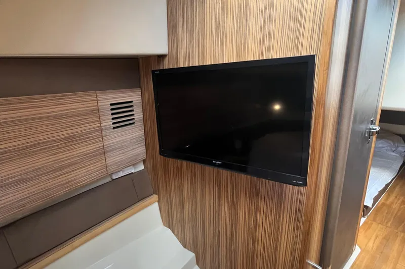 Slide: The Image of 2016 Chris-Craft Launch 36 interior with wood paneling and mounted TV. - 35