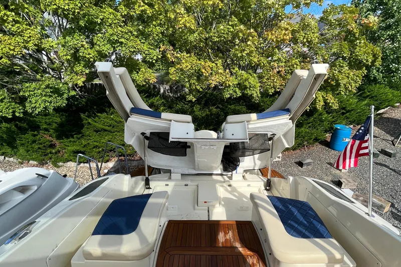 Slide: The Image of 2016 Chris-Craft Launch 36 boat with seating, American flag, and lush greenery background. - 53