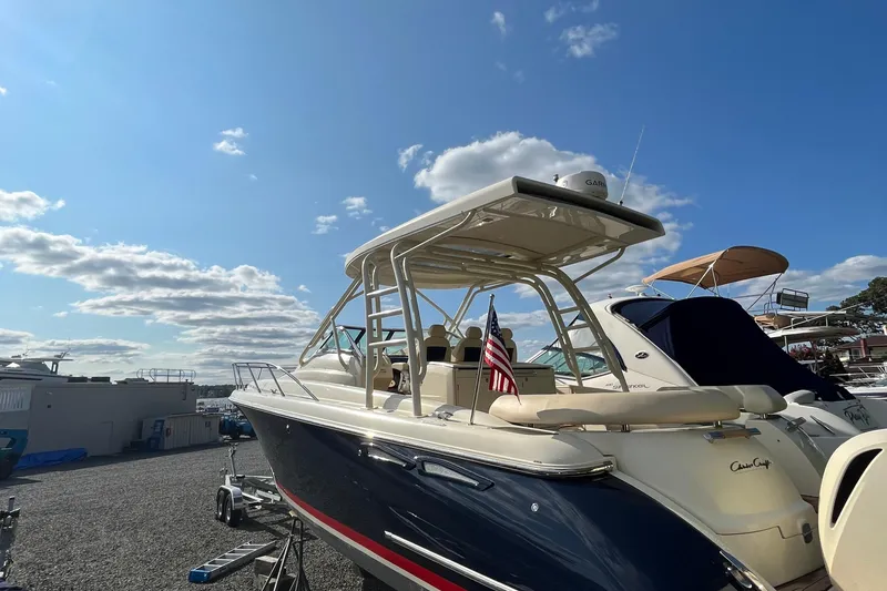 Slide: The Image of 2016 Chris-Craft Launch 36 boat with American flag, parked under a clear blue sky. - 6