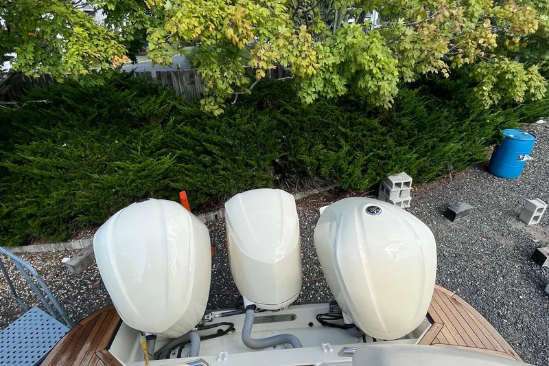 Slide: The Image of Three outboard motors on a 2016 Chris-Craft Launch 36 boat, surrounded by greenery. - 8