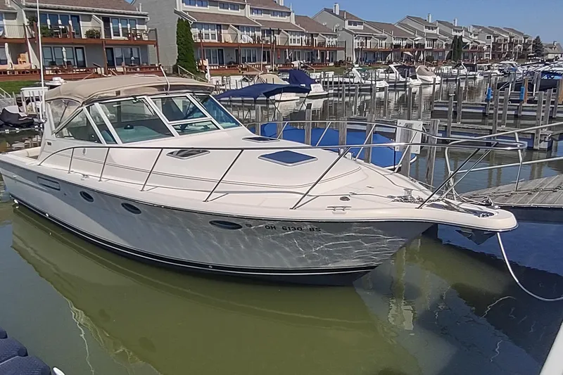 The Image of 1996 Tiara Yachts 3100 Open docked in a marina, surrounded by waterfront homes. - 0