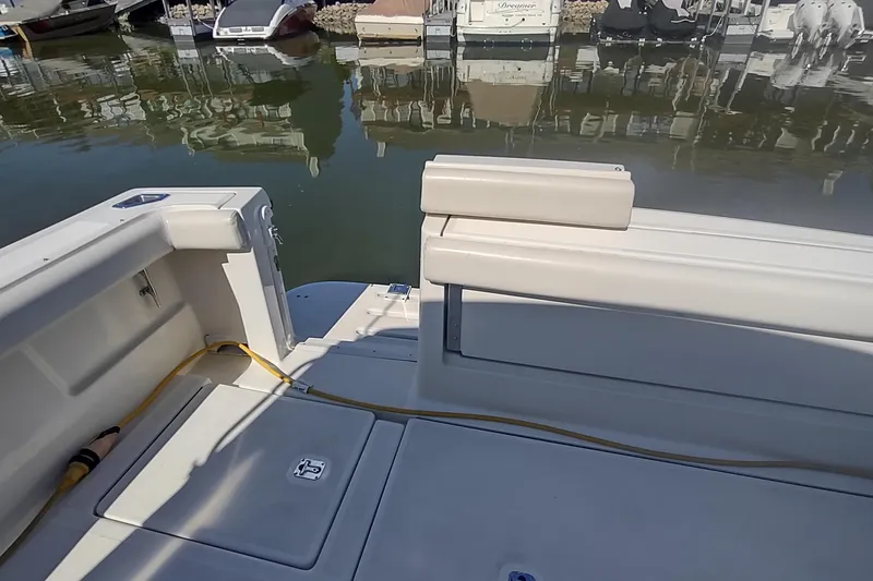 Slide: The Image of 1996 Tiara Yachts 3100 Open boat interior, docked with visible seating and storage. - 11