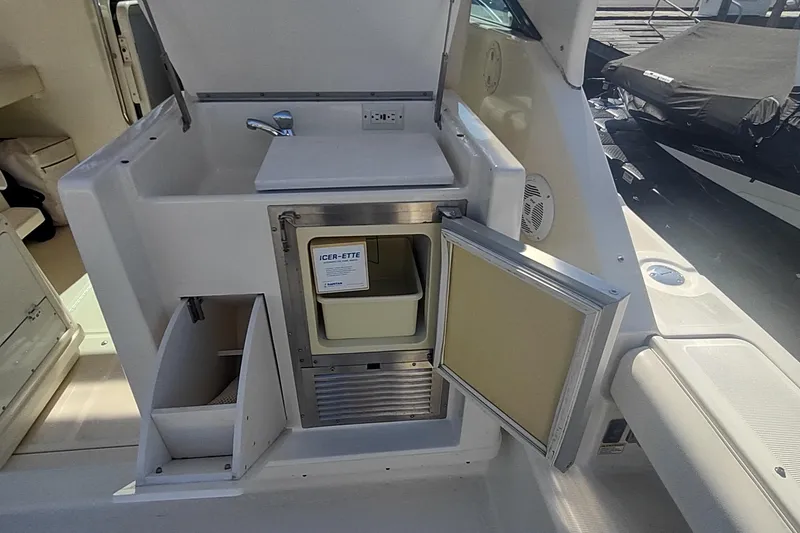 Slide: The Image of 1996 Tiara Yachts 3100 Open boat interior with sink and storage compartments. - 12