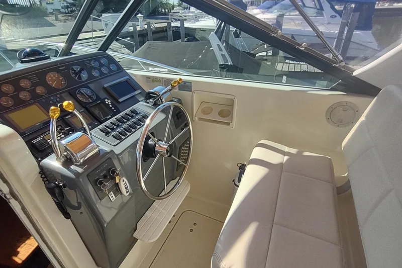 Slide: The Image of 1996 Tiara Yachts 3100 Open helm with steering wheel and control panel. - 13