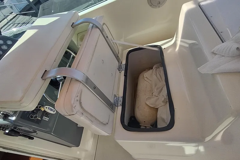 Slide: The Image of 1996 Tiara Yachts 3100 Open storage compartment with open lid, revealing interior contents. - 17