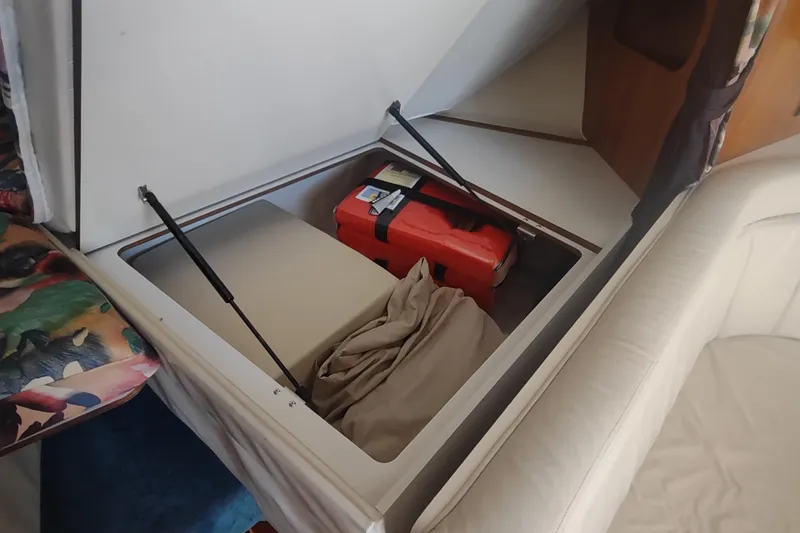 Slide: The Image of Storage compartment in a 1996 Tiara Yachts 3100 Open, featuring a life jacket and fabric. - 18