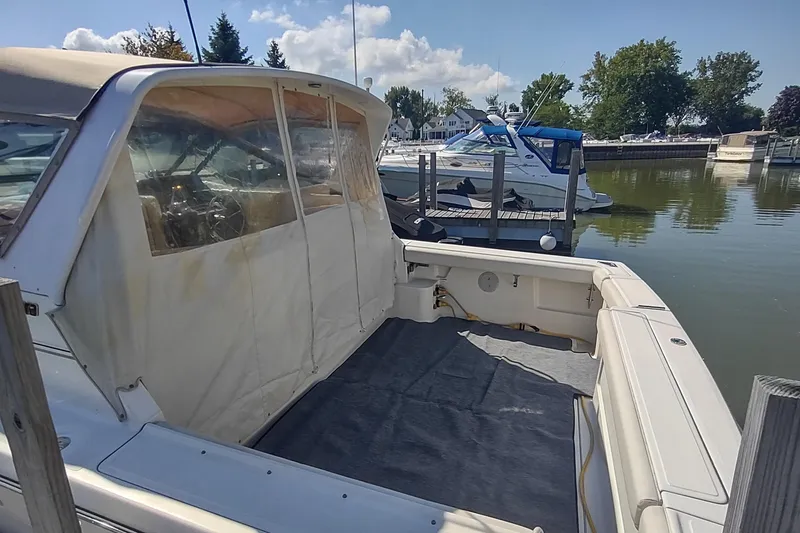 Slide: The Image of 1996 Tiara Yachts 3100 Open docked, featuring spacious cockpit and covered helm area. - 2