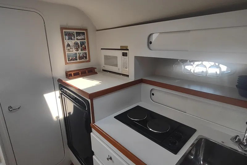 Slide: The Image of 1996 Tiara Yachts 3100 Open galley with stove, microwave, and compact design. - 20