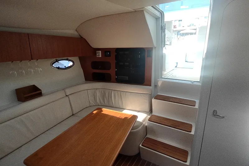 Slide: The Image of Interior of 1996 Tiara Yachts 3100 Open, featuring cozy seating and wooden table. - 21
