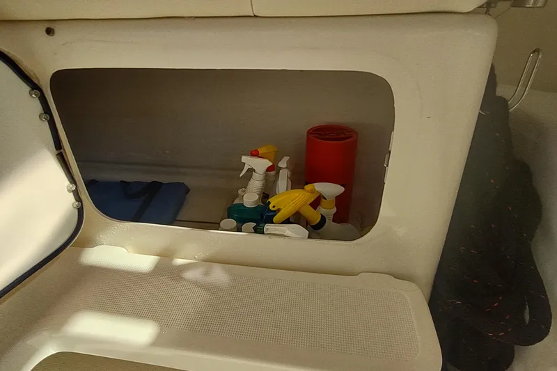 Slide: The Image of Storage compartment on a 1996 Tiara Yachts 3100 Open, containing cleaning supplies and equipment. - 28