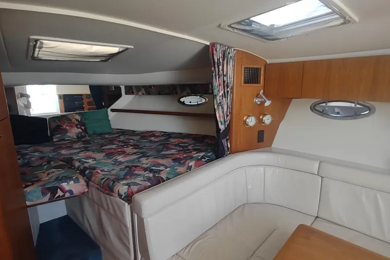 Slide: The Image of Interior of 1996 Tiara Yachts 3100 Open, featuring cozy cabin and seating area. - 4