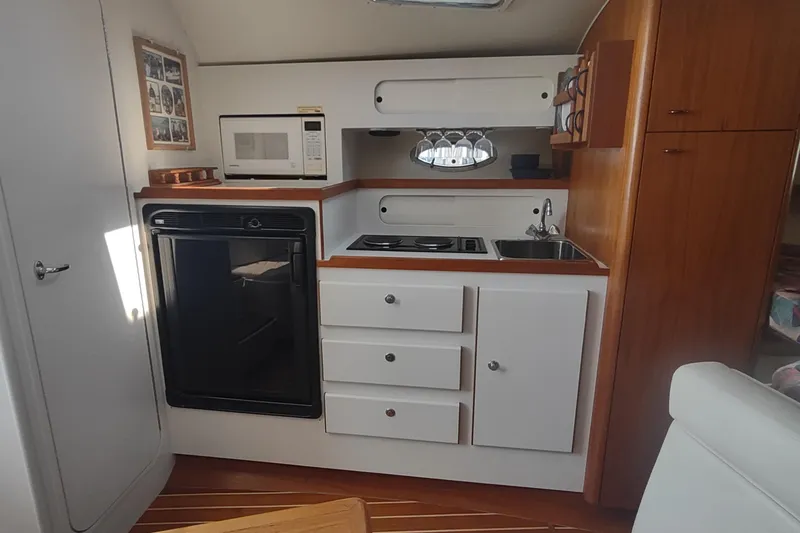 Slide: The Image of Interior of 1996 Tiara Yachts 3100 Open, featuring a compact kitchen with appliances. - 5