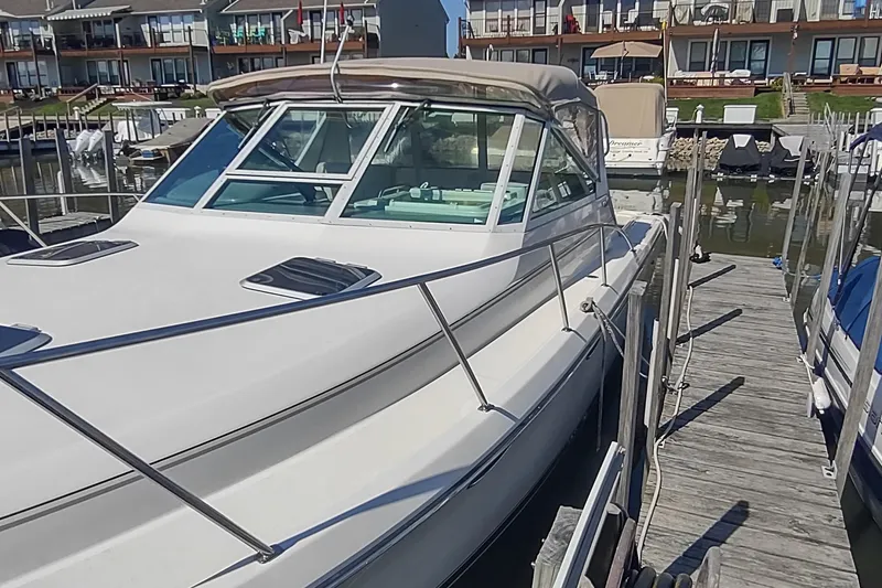 Slide: The Image of 1996 Tiara Yachts 3100 Open docked at marina, showcasing sleek design and spacious deck. - 50