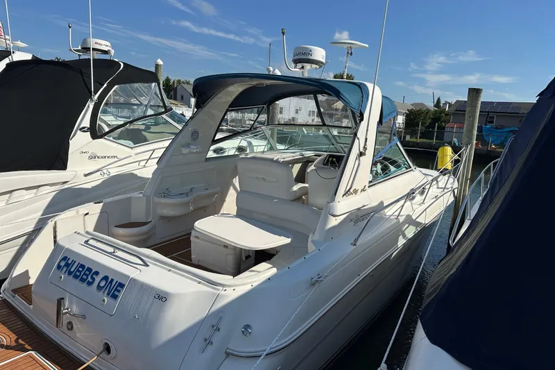 Slide: The Image of 2000 Sea Ray 310 Sundancer docked, featuring spacious cockpit and sleek design. - 1