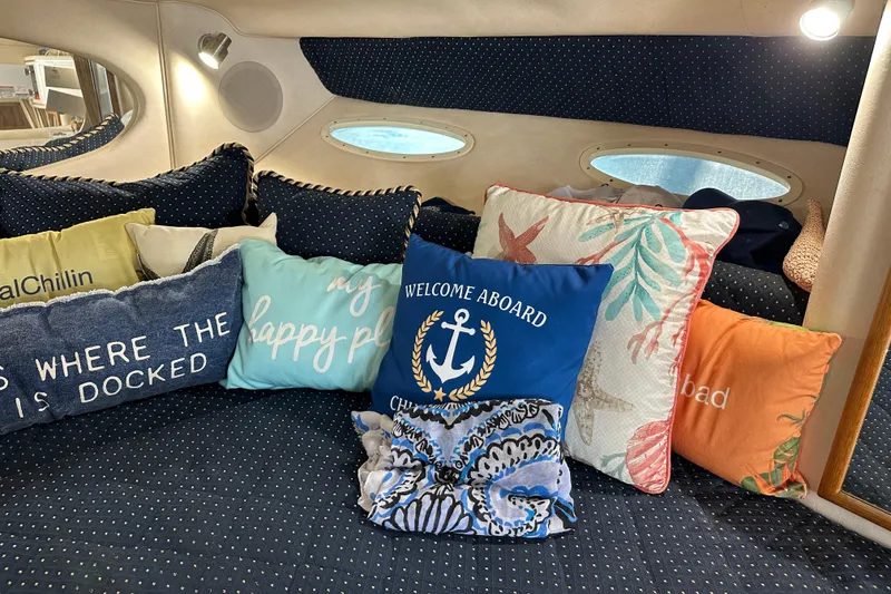 Slide: The Image of Cozy cabin interior of 2000 Sea Ray 310 Sundancer with decorative pillows and porthole windows. - 14