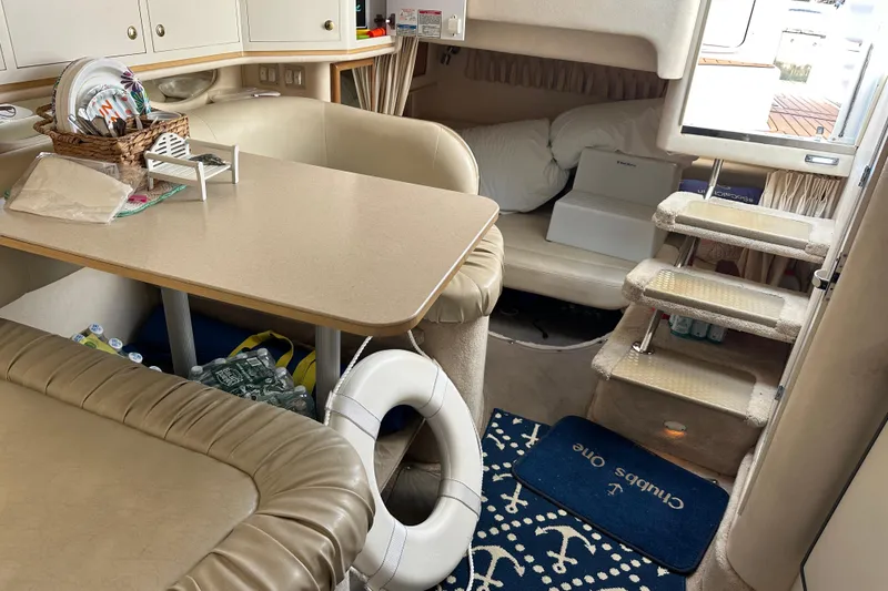Slide: The Image of Interior of a 2000 Sea Ray 310 Sundancer boat with cozy seating and dining area. - 15