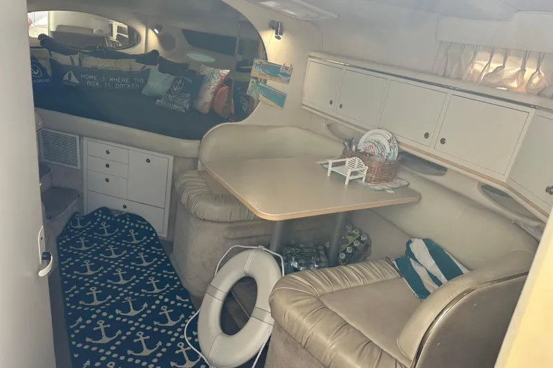 Slide: The Image of Interior of a 2000 Sea Ray 310 Sundancer with cozy seating and nautical decor. - 19