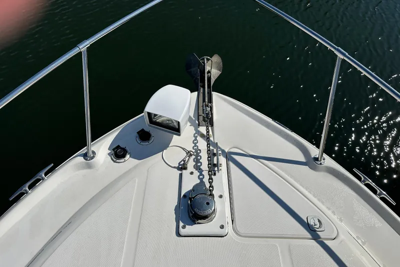Slide: The Image of Bow of 2000 Sea Ray 310 Sundancer with anchor and railing on calm water. - 5