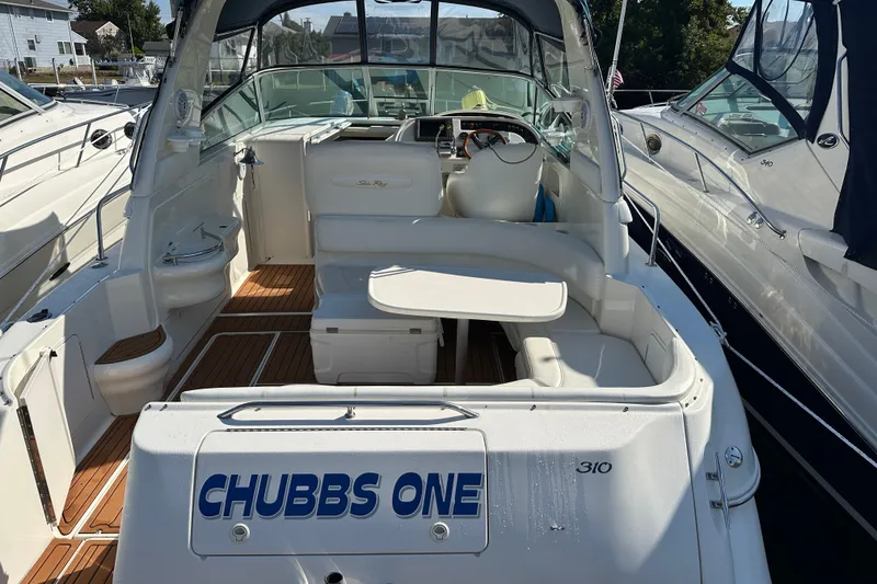 Slide: The Image of 2000 Sea Ray 310 Sundancer boat interior with seating and helm, docked at marina. - 7