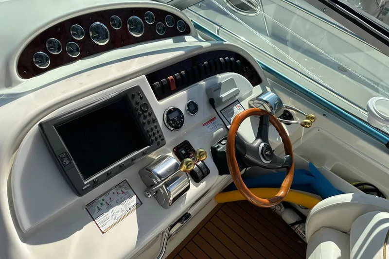 Slide: The Image of Cockpit of 2000 Sea Ray 310 Sundancer with steering wheel and navigation controls. - 8