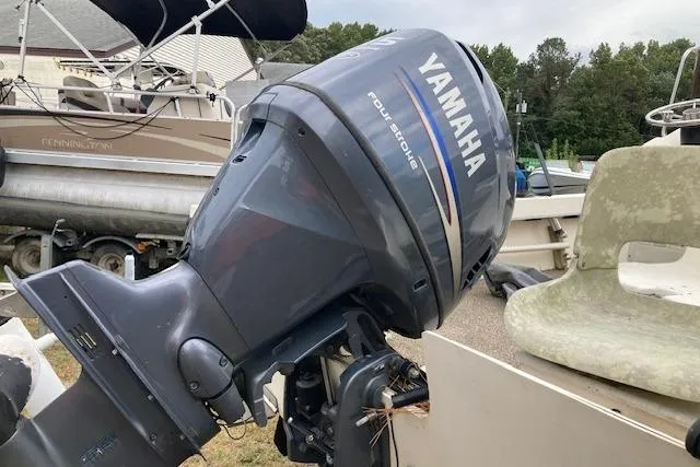 Slide: The Image of 1991 Parker 1801 Center Console with Yamaha four-stroke outboard motor in a boatyard. - 4