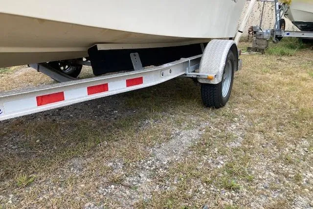 Slide: The Image of 1991 Parker 1801 Center Console boat on a trailer, parked on grass. - 9