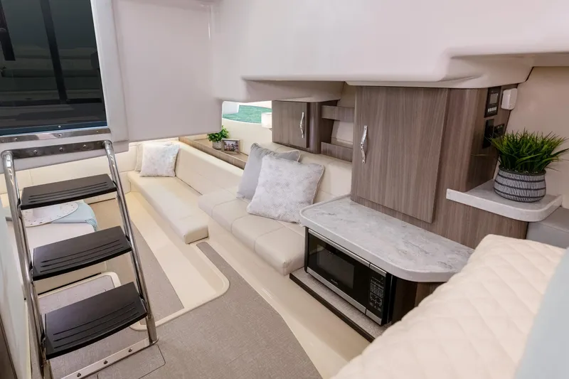 Slide: The Image of Interior of 2026 Regal 36 Grande Coupe yacht with modern seating and kitchenette. - 17