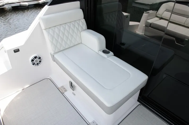 Slide: The Image of Luxurious seating on 2026 Regal 36 Grande Coupe yacht, featuring white upholstery and cup holder. - 5