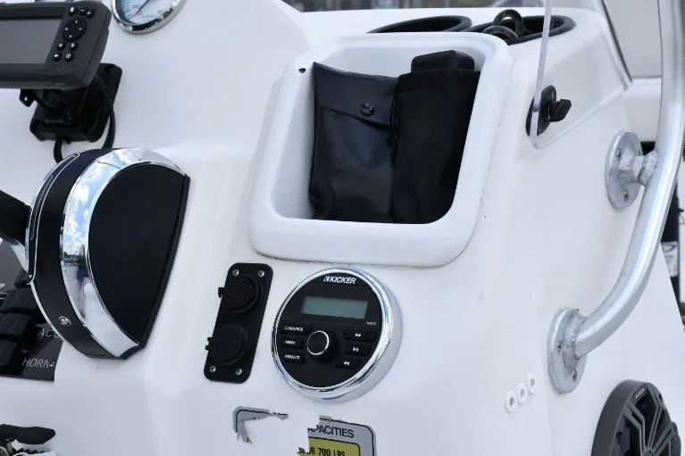 Slide: The Image of Control panel of 2022 ALK2 Powerboats 18CRS with audio system and storage compartment. - 18