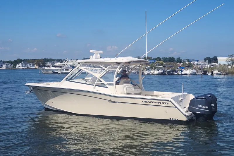Slide: The Image of 2016 Grady-White Freedom 335 boat on water, featuring Yamaha engines, clear sky background. - 1