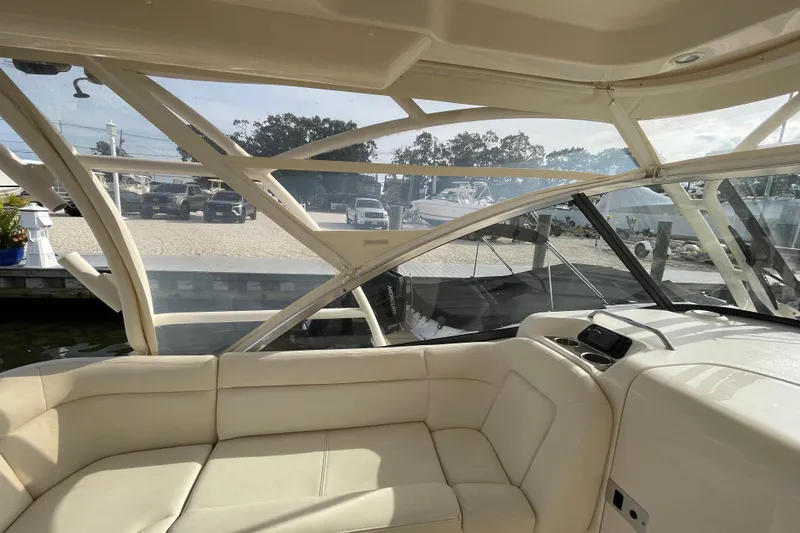 Slide: The Image of Interior view of 2016 Grady-White Freedom 335 boat with beige seating and clear windows. - 48