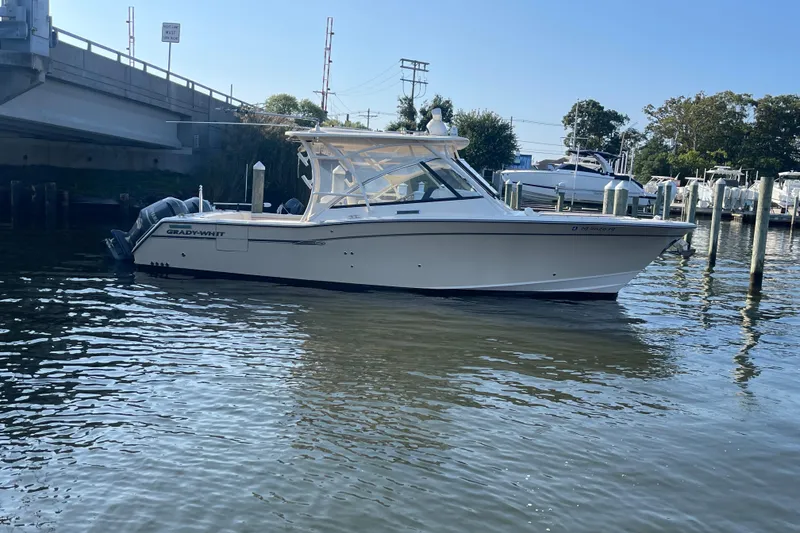Slide: The Image of 2016 Grady-White Freedom 335 boat docked near a bridge in a marina. - 9