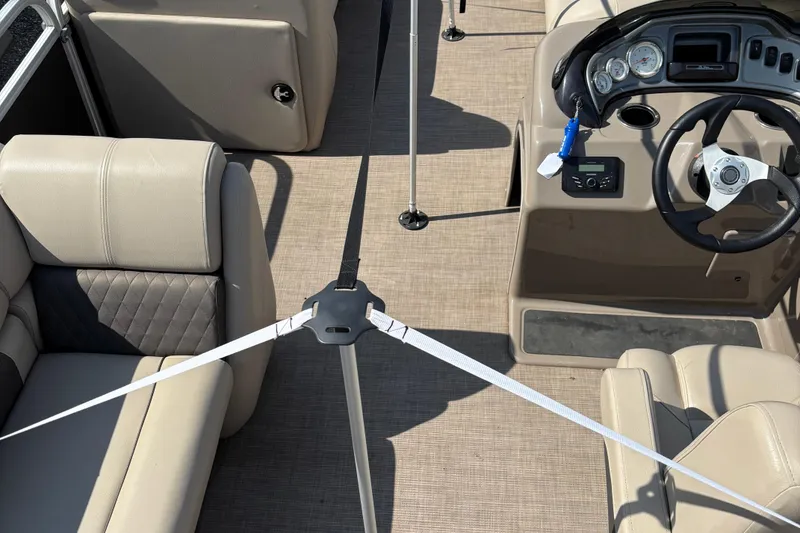 Slide: The Image of 2022 Sun Tracker Party Barge 20 DLX interior with beige seating and steering console. - 7