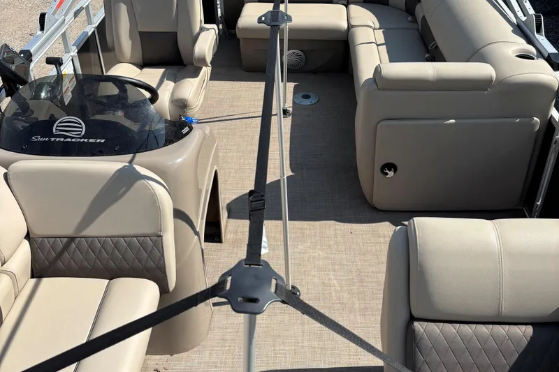 Slide: The Image of 2022 Sun Tracker Party Barge 20 DLX interior with beige seating and steering console. - 8