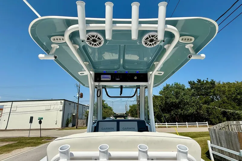 Slide: The Image of 2026 Sea Hunt Gamefish 25 boat with T-top and rod holders, viewed from the rear. - 12
