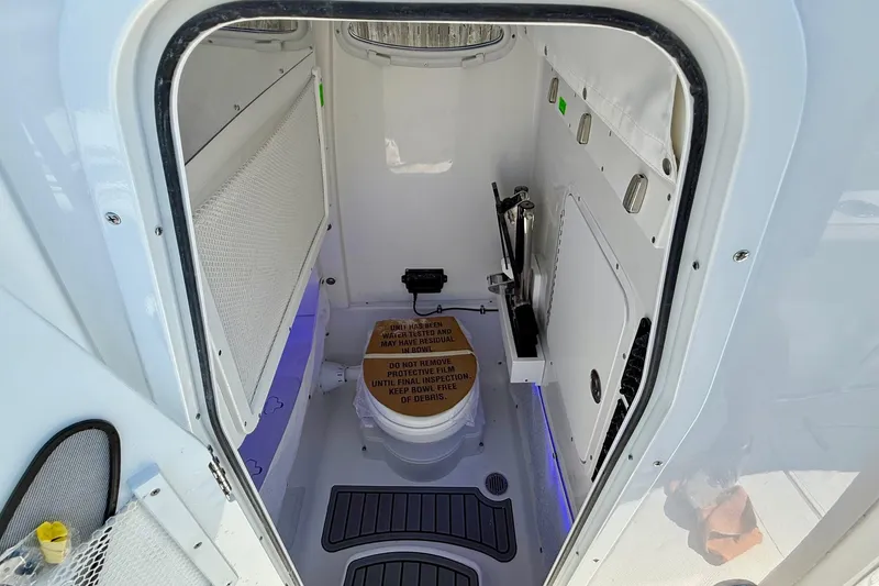 Slide: The Image of 2026 Sea Hunt Gamefish 25 boat interior with compact marine toilet and storage. - 14