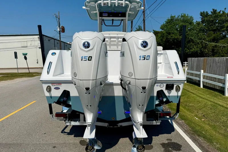 Slide: The Image of 2026 Sea Hunt Gamefish 25 with dual Yamaha 150 engines, parked on a street. - 3