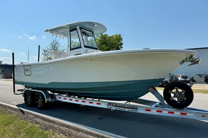 Slide: The Image of 2026 Sea Hunt Gamefish 25 boat on trailer, parked outdoors under clear sky. - 5