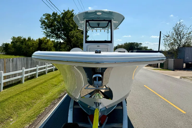 Slide: The Image of 2026 Sea Hunt Gamefish 25 boat on trailer, parked on a sunny road. - 6